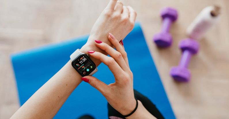 Trackers - Anonymous sportswoman checking smart watch and sitting on mat