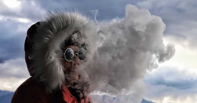 Smoke Detectors - A person wearing a red jacket and goggles smoking