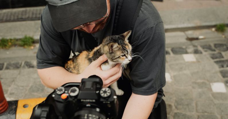 Pet Cameras - Man with Camera Holding Kitten on Street