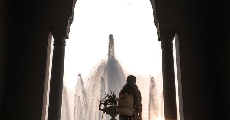 Water Fountains - Woman Standing Near Plant